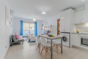 a white kitchen with a table and chairs in it at Casa More Alcalá Center in Alcalá
