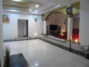 Habitación grande con suelo de baldosa blanca grande con columnas en Welcome To Our Lovely 3-Bed Apartment in Abidjan, en Cocody