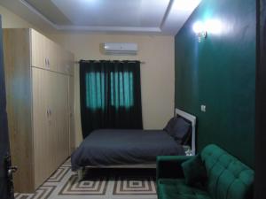 a small room with a bed and a couch at Welcome To Our Lovely 3-Bed Apartment in Abidjan in Cocody