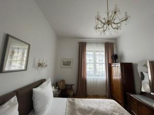 a bedroom with a bed and a chandelier at Villa Musik - Historical apartments in Baden in Baden