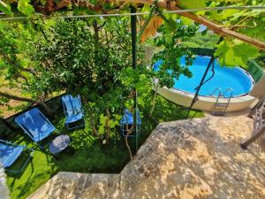 - une vue sur la piscine entourée de chaises et de brousse dans l'établissement Holiday Home Omindula, à Jesenice