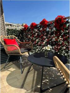 a patio with two chairs and a table and flowers at Elena 100 m2 in Marseille