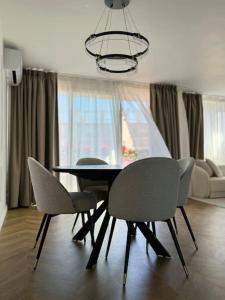 a dining table and chairs in a living room at Elena 100 m2 in Marseille