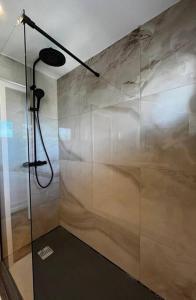 a shower with a glass wall in a bathroom at Elena 100 m2 in Marseille