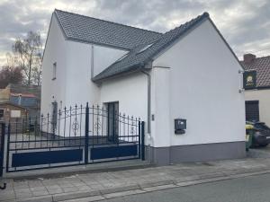 a white building with a black fence at La maison de Timao in Hannut