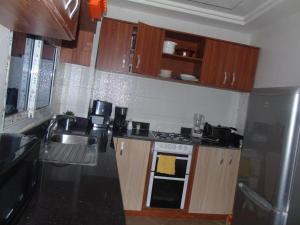 a kitchen with a sink and a stove top oven at Welcome To Our Lovely 3-Bed Apartment in Abidjan in Cocody