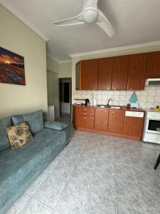 a living room with a couch and a kitchen at Calypso Seaside Apartment in Paleo Tsifliki