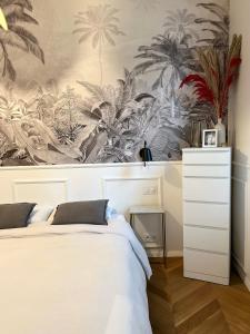 a bedroom with a wall mural of palm trees at Paris 16 lux and cozy 2 bedroom in Paris