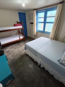 una camera da letto con un letto e una finestra di Pousada Oceano Azul, beira mar a Ilha do Mel