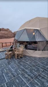 a man laying in a tent in the desert at desert wadi rum camp in Wadi Rum