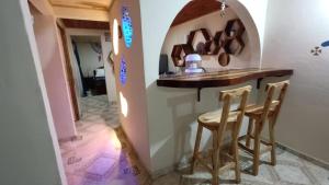 a kitchen with a counter and stools in a room at susurros del río in Pijao +4 photos