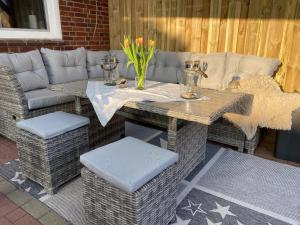 a table and chairs and a couch on a patio at Ferienhaus Norddeichkieker in Norddeich