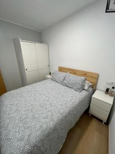 1 dormitorio con 1 cama con cabecero de madera en Apartamento Baixo da Barbeira, en Cangas de Morrazo