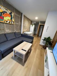 Sala de estar con sofá azul y mesa de centro en Apartamento Baixo da Barbeira, en Cangas de Morrazo