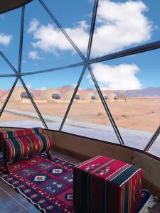 a room with a view of the desert from a window at desert wadi rum camp in Wadi Rum