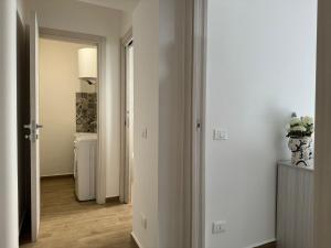 een hal met een kamer met witte muren en houten vloeren bij Za Nedda Home in Fiumefreddo di Sicilia