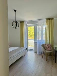 1 dormitorio con cama, ventana y silla en Apartment ZOi, en Šamorín