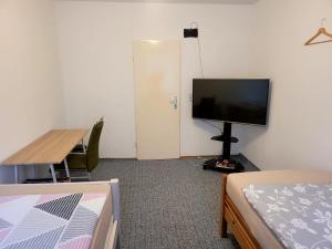 um quarto com uma televisão de ecrã plano e uma cama em Perfect Resting Rooms em Bremen