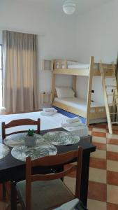 a room with a table and chairs and bunk beds at Hotel Sirena in Vlorë