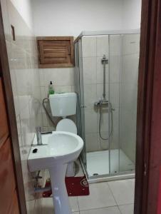 a bathroom with a toilet and a sink and a shower at Pousada Bem Posta in São Tomé