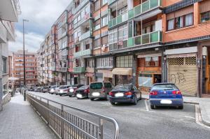 a row of cars parked on a street with buildings at Vivienda Turística, Refugio Azkue Encanto y Comodidad in Bilbao