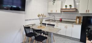 a kitchen with a table with chairs and a sink at Casa Tambo I in Pontevedra