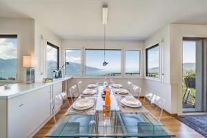 Le Châtelard-Montreux的住宿－Panoramic 3BD Dream Family Villa in Montreux by GuestLee，一间带桌子和一些窗户的用餐室