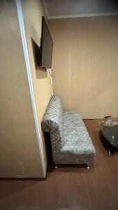 uma cadeira num quarto com uma televisão em Арыстан гостиница em Zaozërnyy
