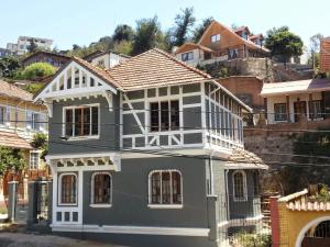 a blue house with white trim on a hill at Comarca Valparaíso in Valparaíso