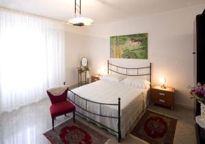 a bedroom with a bed and a red chair at B&B Vigna La Corte in Alessano