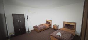 a hotel room with two beds and a dresser at Blue Bird House in Wadi Musa