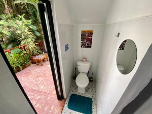 a small bathroom with a toilet and a window at Hostel Hospedarte Chapultepec in Guadalajara