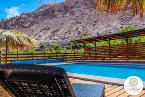 una piscina con una montaña en el fondo en Lodge El Pedregan, en Codpa