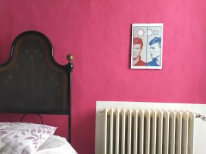 um quarto com uma parede rosa e um radiador em Il cortile di zia em Cagli