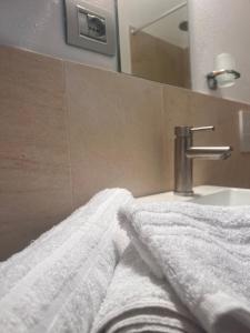 uma casa de banho com uma toalha branca ao lado de um lavatório em Olivetta House Holiday em Moneglia