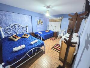 um quarto azul com 2 camas e almofadas em Hotel Aguilar em Uyuni