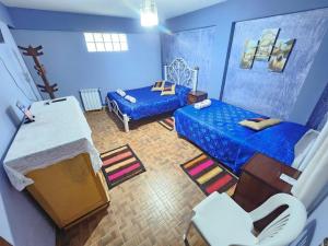 Cette chambre bleue comprend un lit et un canapé. dans l'établissement Hotel Aguilar, à Uyuni