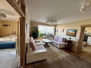 a living room with a bed and a couch and a table at VIsagino Apartment in Visaginas