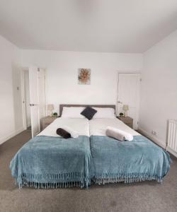 a white bedroom with a large bed with two pillows at Modish 1Bed Apartment with Free Street Parking in Frodingham