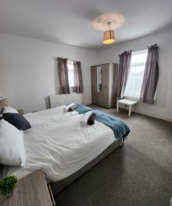 a bedroom with a large bed with two stuffed animals on it at Modish 1Bed Apartment with Free Street Parking in Frodingham