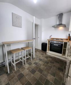 a kitchen with a counter and a table and a stove at Modish 1Bed Apartment with Free Street Parking in Scunthorpe