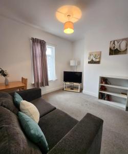 a living room with a couch and a tv at Modish 1Bed Apartment with Free Street Parking in Frodingham