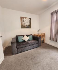 ein Wohnzimmer mit einem Sofa und einem Tisch in der Unterkunft Modish 1Bed Apartment with Free Street Parking in Scunthorpe