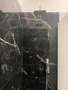 a bathroom with a black marble shower at Ellis-Suites Nea Peramos Kavala in Nea Peramos