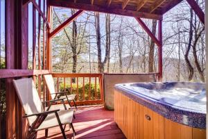 a hot tub on a deck with two chairs at Secluded Sevierville Condo with Hot Tub and Mtn Views! in Sevierville