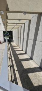 a long hallway with shadows on the side of a building at Option Full Service Residence in Rio de Janeiro