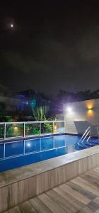 a swimming pool at night with lights on a building at Option Full Service Residence in Rio de Janeiro