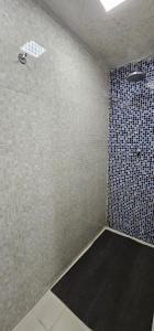 a bathroom with a shower with a tiled wall at Option Full Service Residence in Rio de Janeiro