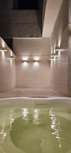 a large pool of green water in a room with lights at Option Full Service Residence in Rio de Janeiro