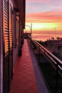 een balkon van een gebouw met een zonsondergang op de achtergrond bij La Perla in Taormina